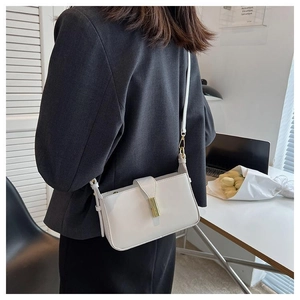 Gros plan d'un sac à bandoulière en cuir blanc avec boucle dorée sur un mannequin
