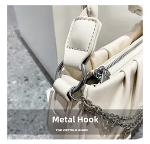 Détail du crochet argenté et de la sangle tissée sur sac nuage plissé crème