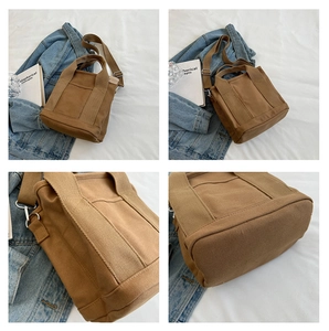 Detail view of brown canvas tote bag showing stitching and detachable shoulder strap