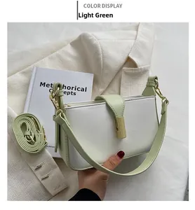 Détail d'un sac selle en cuir patchwork vert clair et blanc avec une boucle en métal doré