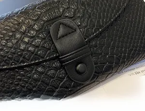 Detail of elegant crocodile-patterned black wallet with refined leather snap closure