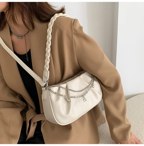 Détail du sac hobo blanc cassé plissé avec bandoulière tressée et chaîne cœur