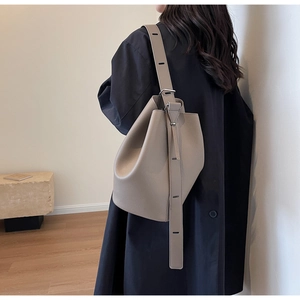 Close-up of elephant gray pebble leather bucket bag featuring adjustable wide shoulder strap