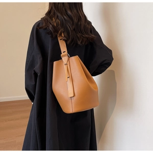 Brown lychee leather bucket bag shown on model for a trendy crossbody style
