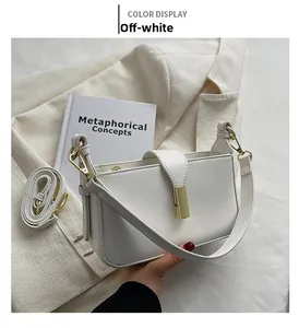 Détail du sac bandoulière en cuir blanc cassé avec fermoir doré et doubles sangles