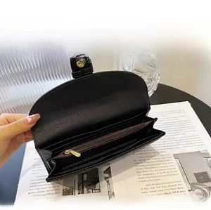 Detail view of the black wallet's internal structure showing card slots and golden zippers