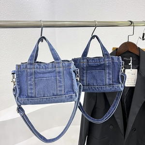 Versatile denim tote bag in light and dark blue with adjustable straps and contrast stitching