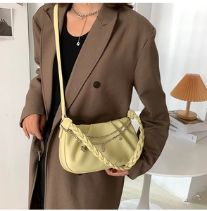 Détail du sac nuage plissé jaune avec poignée tressée et breloques en cœur
