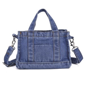 Blue denim tote bag with contrast stitching and detachable shoulder strap in a clean studio view