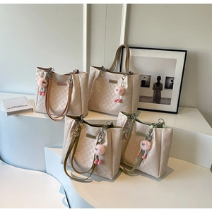 Group shot of checkered tote bags with colorful straps and pink pompom charms