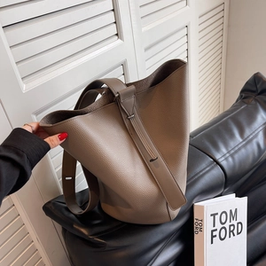 Minimalist taupe lychee leather bucket bag with vertical strap and large capacity