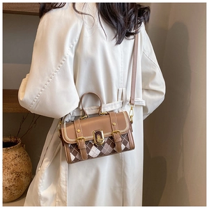 Detail of checkered plaid Boston bag with gold buckle hardware on stylish trench coat