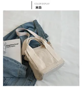 Cream canvas tote bag on white bedding with a denim jacket and a book