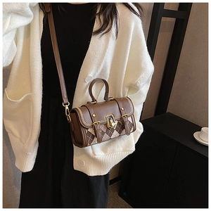 Detail of vintage brown argyle pattern handbag with gold twist lock on white cardigan