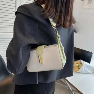 Sac bandoulière minimaliste ivoire et vert avec boucle dorée dans un décor moderne
