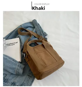 Detail of khaki canvas tote bag with adjustable wide strap and open front pocket