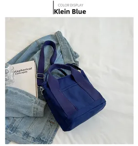 Klein blue canvas tote bag with purple strap styled with denim jacket and books