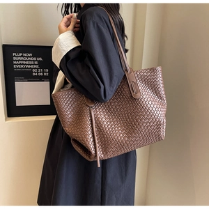 Close-up of brown woven leather texture on a spacious tote bag with shoulder strap
