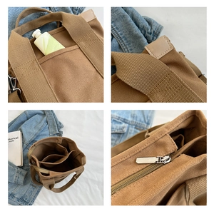 Detail view of brown canvas tote bag featuring leather reinforced handles and compartments