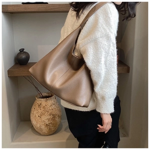 Detail of premium brown pebble leather texture and wide strap on large tote bag