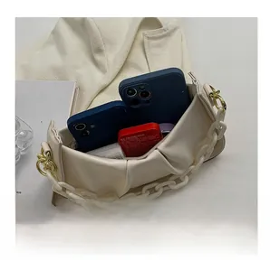 Detail view of the spacious interior and resin chain strap on the beige pleated cloud bag