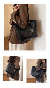 Detail of a black matte leather tote bag with a cute elephant charm and gold hardware