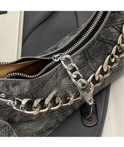 Detail of grey washed denim bag with diamond quilted stitching and silver chain strap