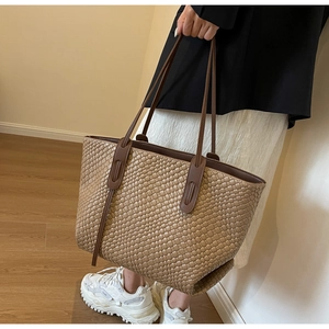Detail view of khaki woven tote bag showing premium synthetic leather texture and long handles