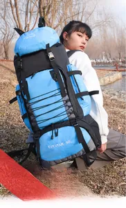 Blue and black 90L outdoor hiking backpack with side straps and mesh pockets in nature