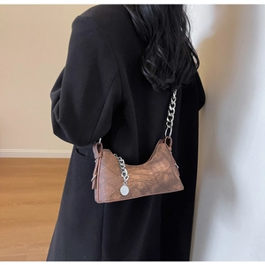Brown vintage crescent bag featuring silver chain strap and distressed stitch details