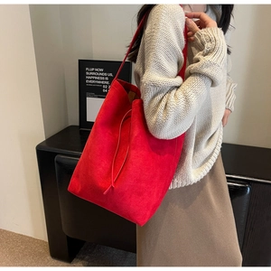 Close-up of a large red suede tote bag showing its premium texture and drawstring design