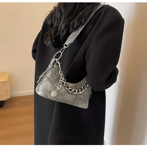Silver hobo bag with thick metal chain detail shown on a black coat outfit