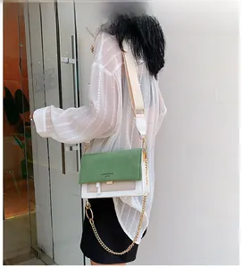 Détail du sac à bandoulière bicolore vert et crème avec bandoulière large en tissu
