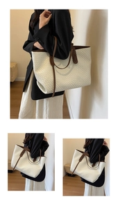 Detail of vintage quilted woven tote bag with brown contrast handles and textured finish