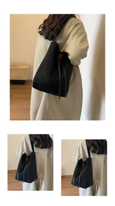 Close-up of black suede tote bag with matte texture and minimalist drawstring details