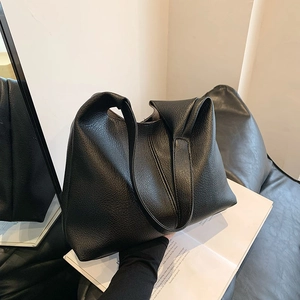 Large black pebbled leather tote bag with minimalist bucket shape for commuting women