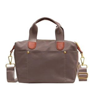 Grey-brown nylon tote bag with leather handles and gold hardware for daily commuting