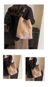 Detail of large suede tote bag featuring a drawstring closure and soft textured finish