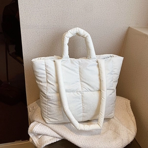 Chic off-white quilted tote bag with subtle glossy dots and padded shoulder straps