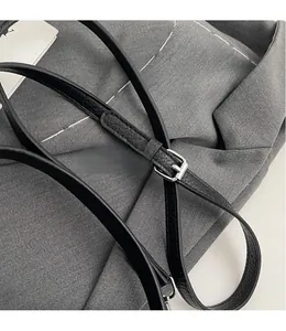 Détail de la bandoulière en cuir noir avec boucle de réglage en métal argenté brillant