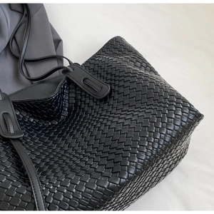 Close-up of black woven quilted pattern and premium leather texture on large tote bag