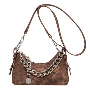 Brown vintage denim patchwork shoulder bag with silver chain and adjustable strap on white