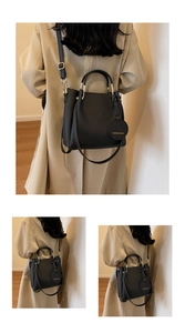 Detail of black litchi pattern leather bucket bag with gold handle and hanging tag