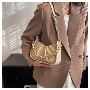 Detail of beige cloud bag featuring soft pleated leather and stylish chunky chain strap