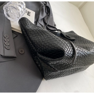Detail of the black leather intrecciato weave and texture on a large tote bag