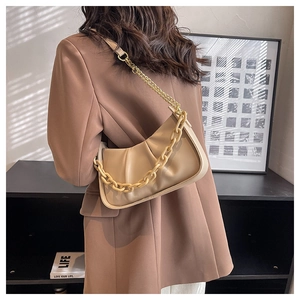 Detail of beige cloud bag featuring soft pleated leather and stylish resin chain strap