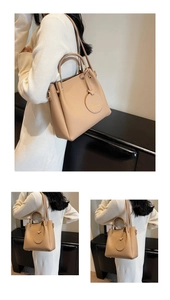 Detail of beige lychee texture leather bucket bag with metal handle and logo charm