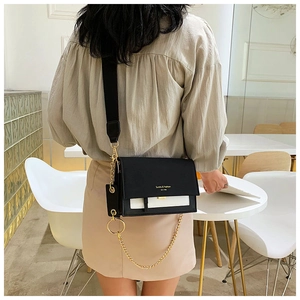 Détail du sac bandoulière noir et blanc avec chaîne dorée et lettrage Sunita & Fashion