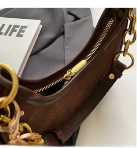 Détail du zip en métal doré et de la texture en daim sur un sac à bandoulière vintage