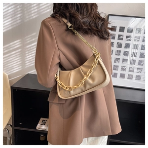 Detail of beige pleated cloud bag with soft leather and chunky chain strap on shoulder